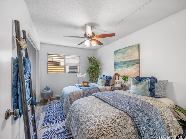 bedroom featuring a textured ceiling, hardwood / wood-style flooring, ceiling fan, and cooling unit