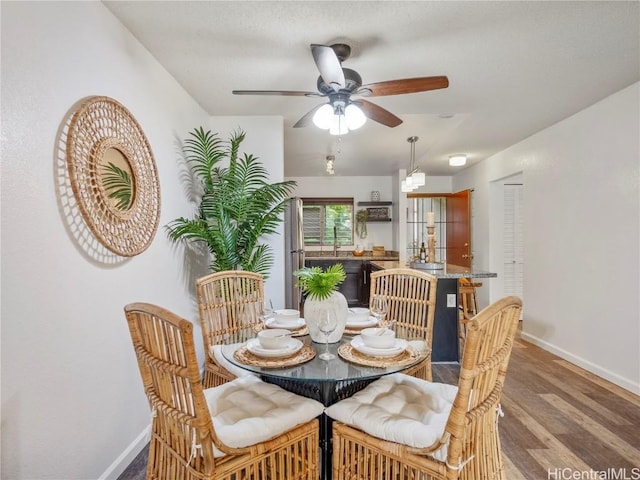 dining area with wood-type flooring and ceiling fan