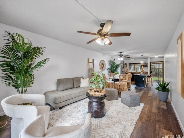 living room featuring ceiling fan and dark hardwood / wood-style flooring