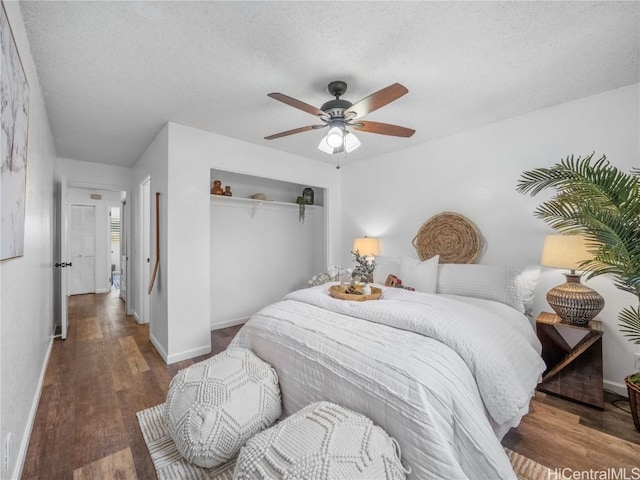 bedroom featuring ceiling fan, a closet, dark hardwood / wood-style floors, and a textured ceiling