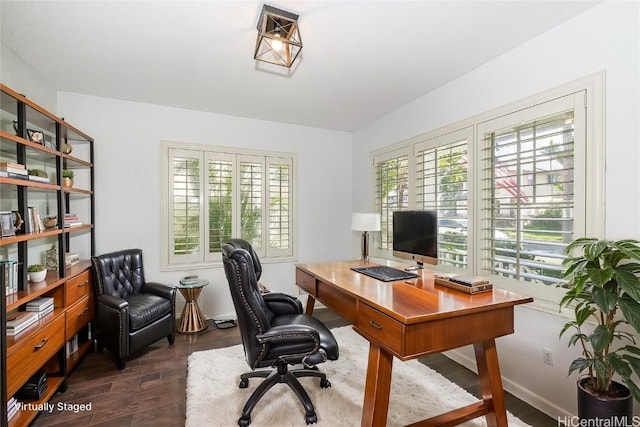 home office with a healthy amount of sunlight and dark hardwood / wood-style floors