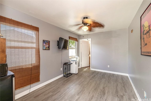 empty room with ceiling fan and hardwood / wood-style flooring