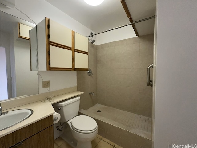 bathroom with tile patterned flooring, vanity, tiled shower, and toilet