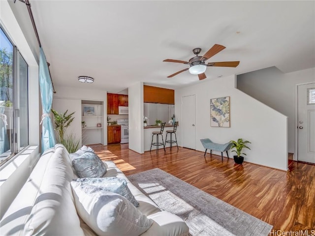 living room with a ceiling fan and wood finished floors