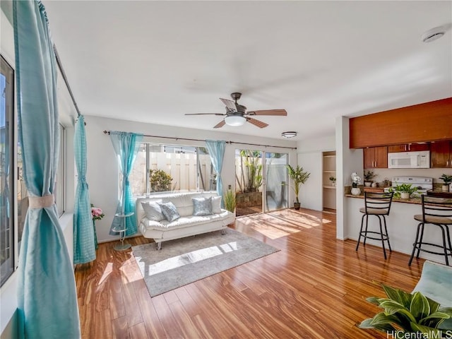 living room featuring ceiling fan and light wood-type flooring