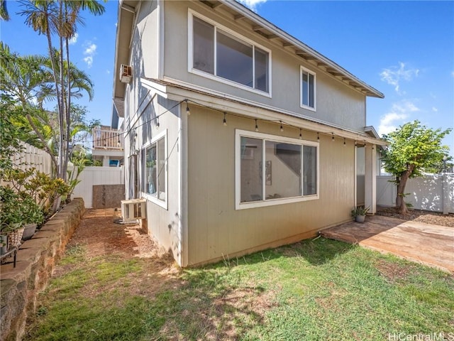 view of property exterior with a lawn and a patio