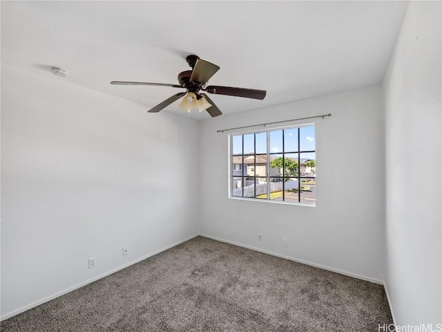 carpeted empty room with baseboards and a ceiling fan