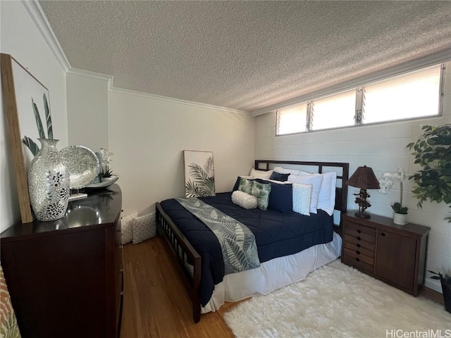 bedroom with light wood-type flooring, a textured ceiling, and ornamental molding