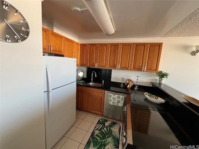 kitchen with sink, white fridge, stainless steel dishwasher, and light tile patterned floors