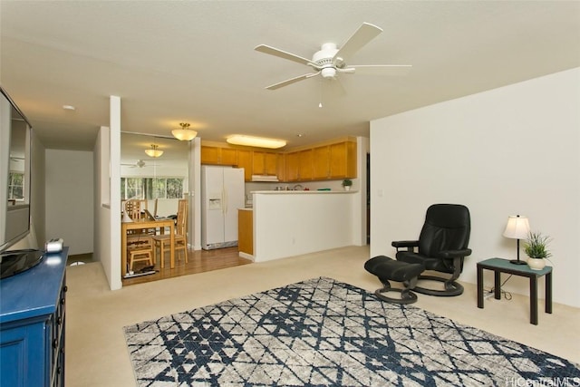 sitting room featuring ceiling fan and light colored carpet