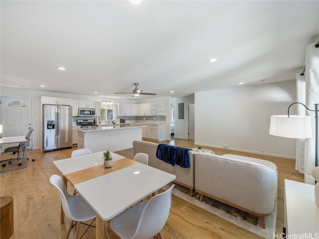 dining room featuring light wood finished floors, baseboards, and recessed lighting