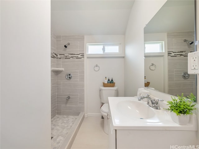 full bathroom with baseboards, a tile shower, vanity, and toilet