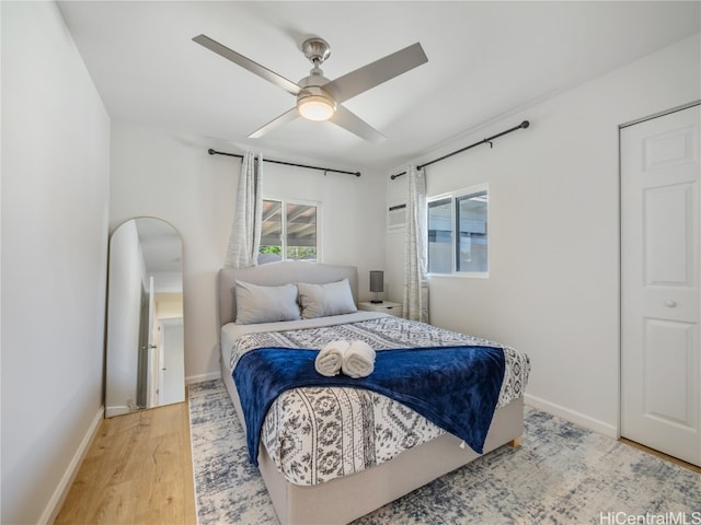 bedroom featuring ceiling fan, baseboards, and wood finished floors