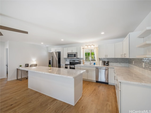 kitchen featuring a center island, stainless steel appliances, white cabinetry, open shelves, and backsplash