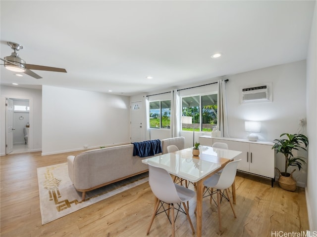 dining space featuring ceiling fan, a wall mounted AC, and light hardwood / wood-style flooring