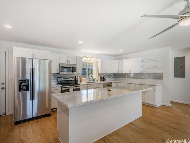 kitchen featuring stainless steel appliances, white cabinets, a kitchen island, and open shelves