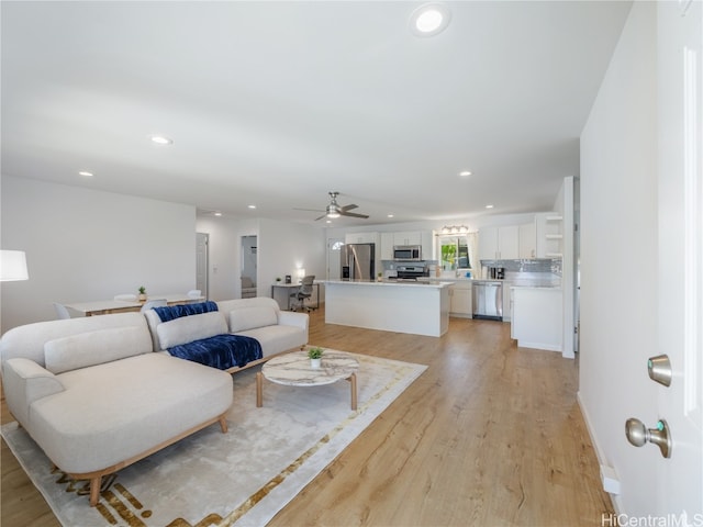 living room featuring ceiling fan, light wood-style flooring, and recessed lighting