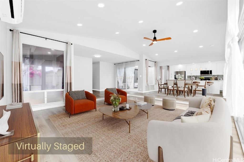 living room featuring lofted ceiling, light wood-type flooring, and ceiling fan