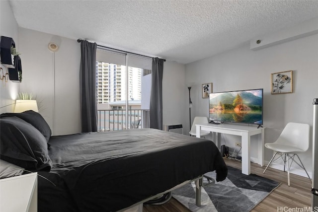 bedroom with wood-type flooring and a textured ceiling