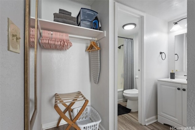 full bathroom with vanity, wood-type flooring, shower / tub combo, and toilet