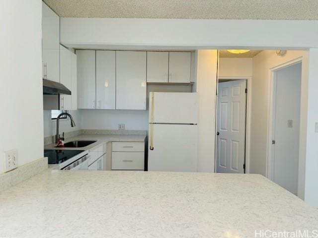 kitchen with sink, range, white refrigerator, a textured ceiling, and kitchen peninsula