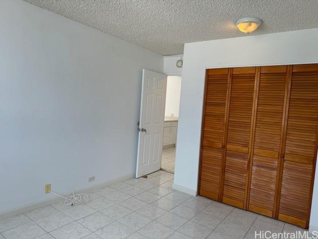 unfurnished bedroom with a closet and a textured ceiling