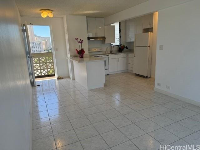 kitchen with sink, white appliances, light tile patterned floors, and a textured ceiling