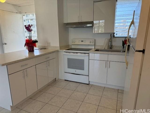 kitchen with light tile patterned flooring, sink, white cabinets, kitchen peninsula, and white appliances