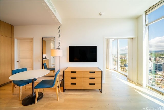 dining area featuring plenty of natural light, expansive windows, and light hardwood / wood-style floors