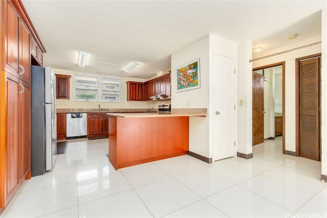 kitchen featuring sink, stainless steel appliances, kitchen peninsula, a breakfast bar, and light tile patterned floors