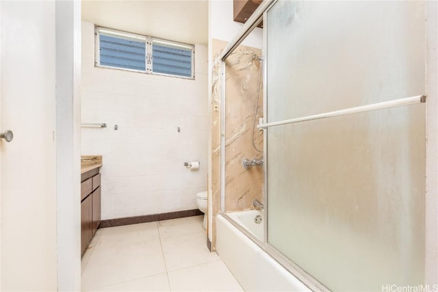 full bathroom featuring tile patterned flooring, vanity, toilet, and shower / bath combination with glass door