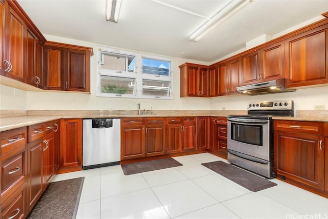 kitchen with light stone counters, sink, light tile patterned floors, and stainless steel appliances