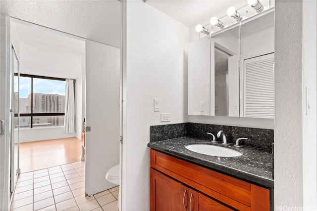 bathroom featuring vanity, tile patterned floors, and toilet