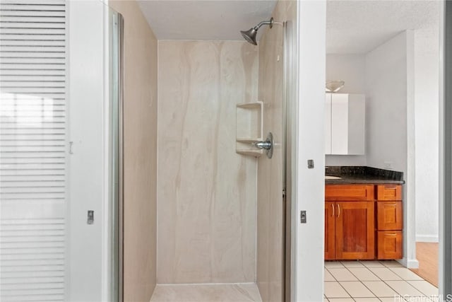 bathroom featuring vanity, tile patterned flooring, and a shower