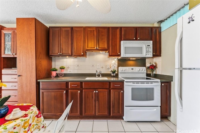 kitchen with white appliances, sink, ceiling fan, light tile patterned floors, and a textured ceiling