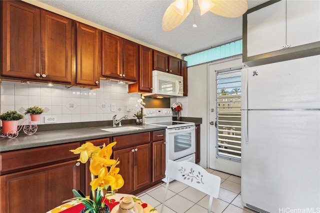 kitchen featuring ceiling fan, sink, a textured ceiling, white appliances, and light tile patterned floors