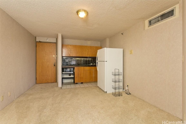 kitchen with white fridge and light carpet