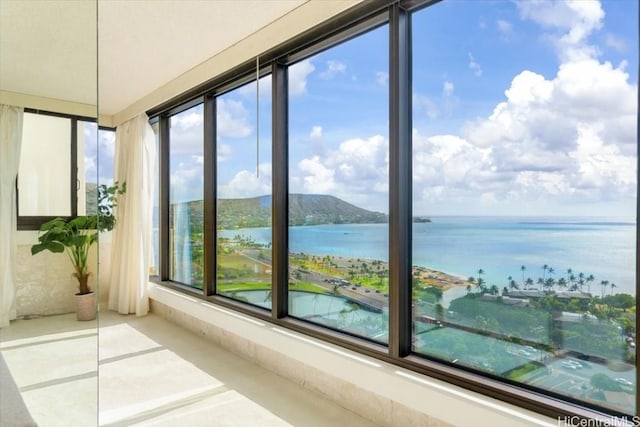 unfurnished sunroom featuring a water view