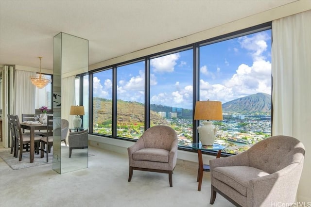 sunroom featuring a mountain view and a notable chandelier