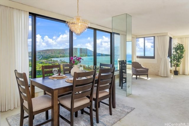 carpeted dining area featuring a water and mountain view and a chandelier