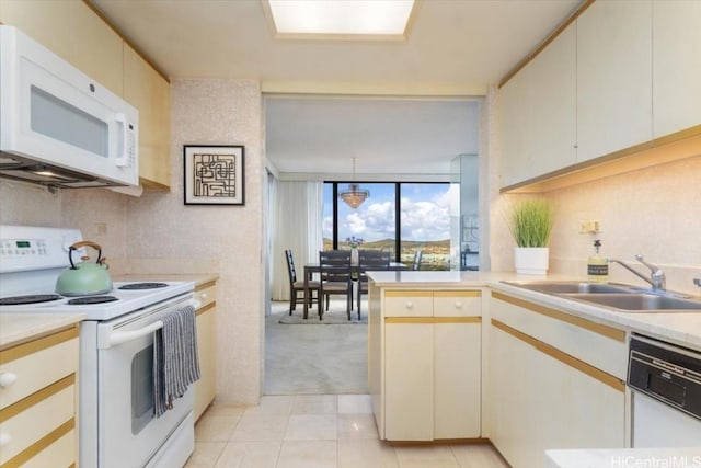 kitchen featuring white cabinets, white appliances, sink, and hanging light fixtures