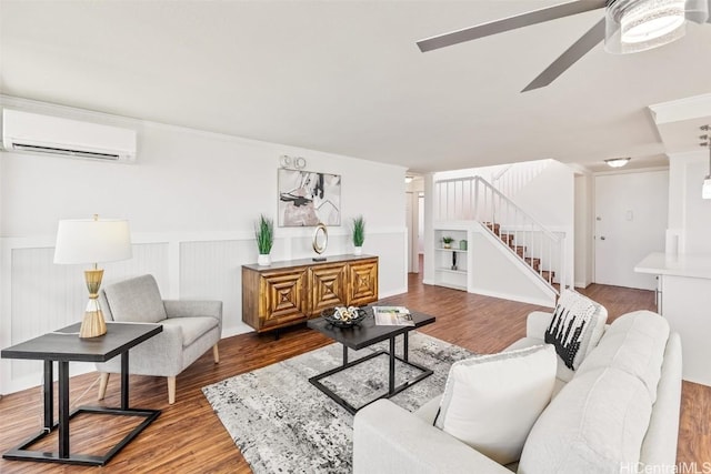 living room with a wall mounted AC, ceiling fan, and hardwood / wood-style floors