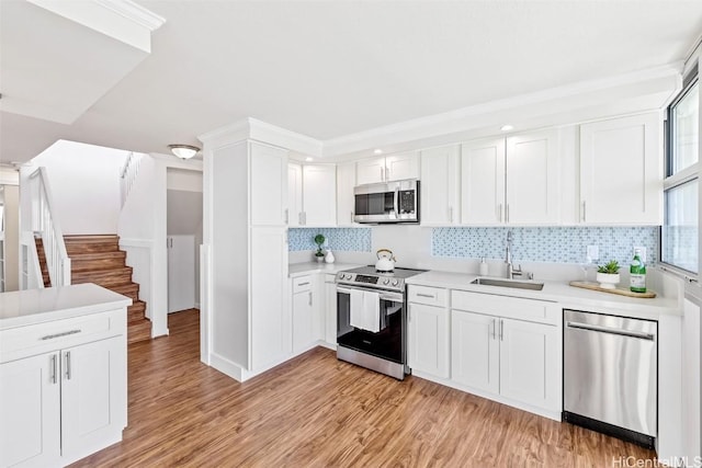 kitchen featuring backsplash, white cabinetry, sink, and stainless steel appliances