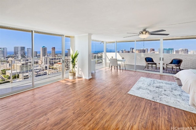 living room featuring hardwood / wood-style floors, ceiling fan, and floor to ceiling windows