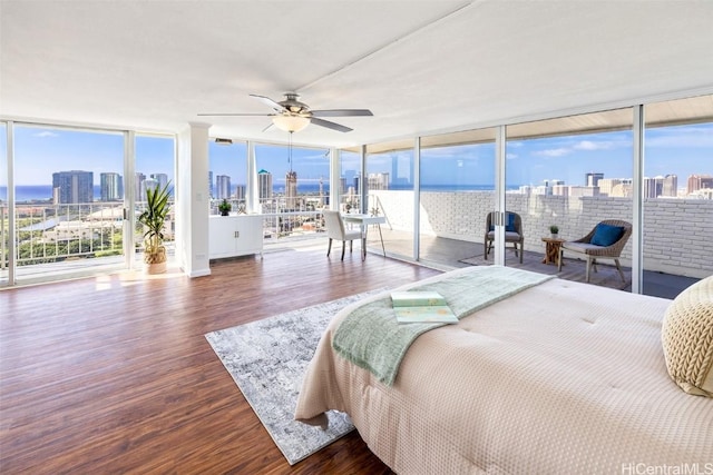 bedroom with access to exterior, ceiling fan, brick wall, and hardwood / wood-style flooring