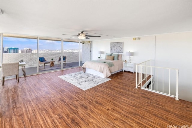 bedroom featuring a wall of windows, dark hardwood / wood-style floors, and ceiling fan