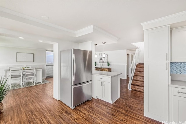 kitchen with white cabinets, decorative light fixtures, dark hardwood / wood-style floors, and stainless steel refrigerator