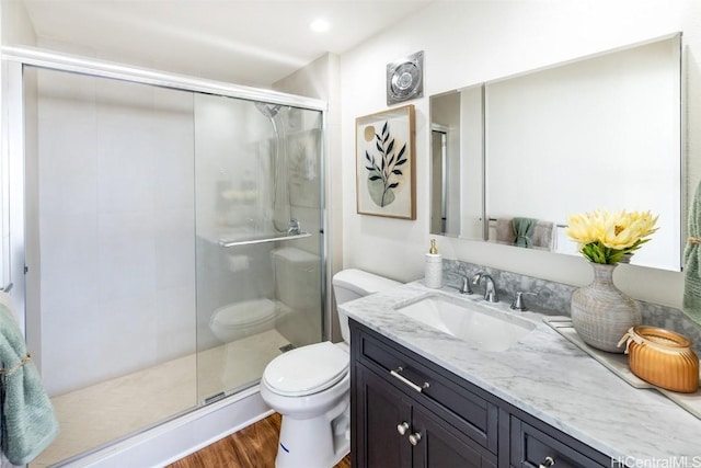 bathroom featuring hardwood / wood-style floors, vanity, toilet, and an enclosed shower