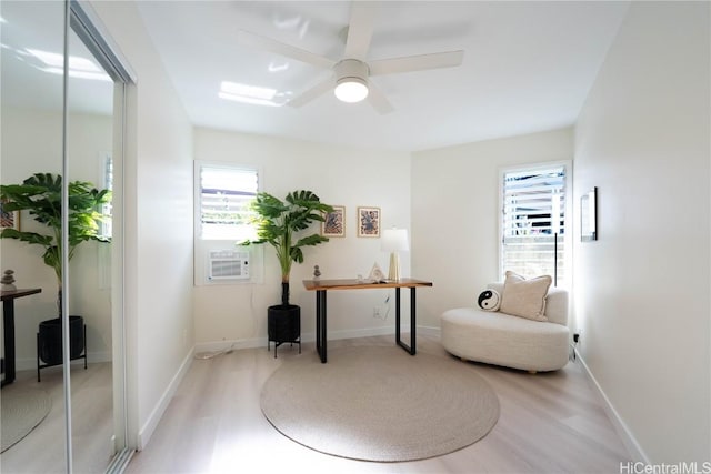 living area featuring ceiling fan, plenty of natural light, and light wood-type flooring