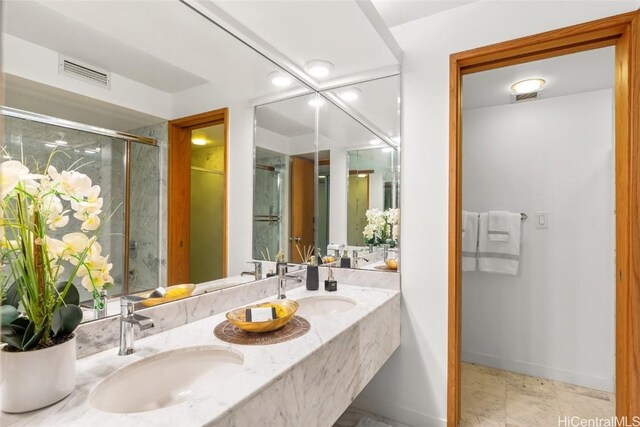 bathroom featuring a shower with door and vanity